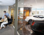 Woman and salesman sitting in car showroom office